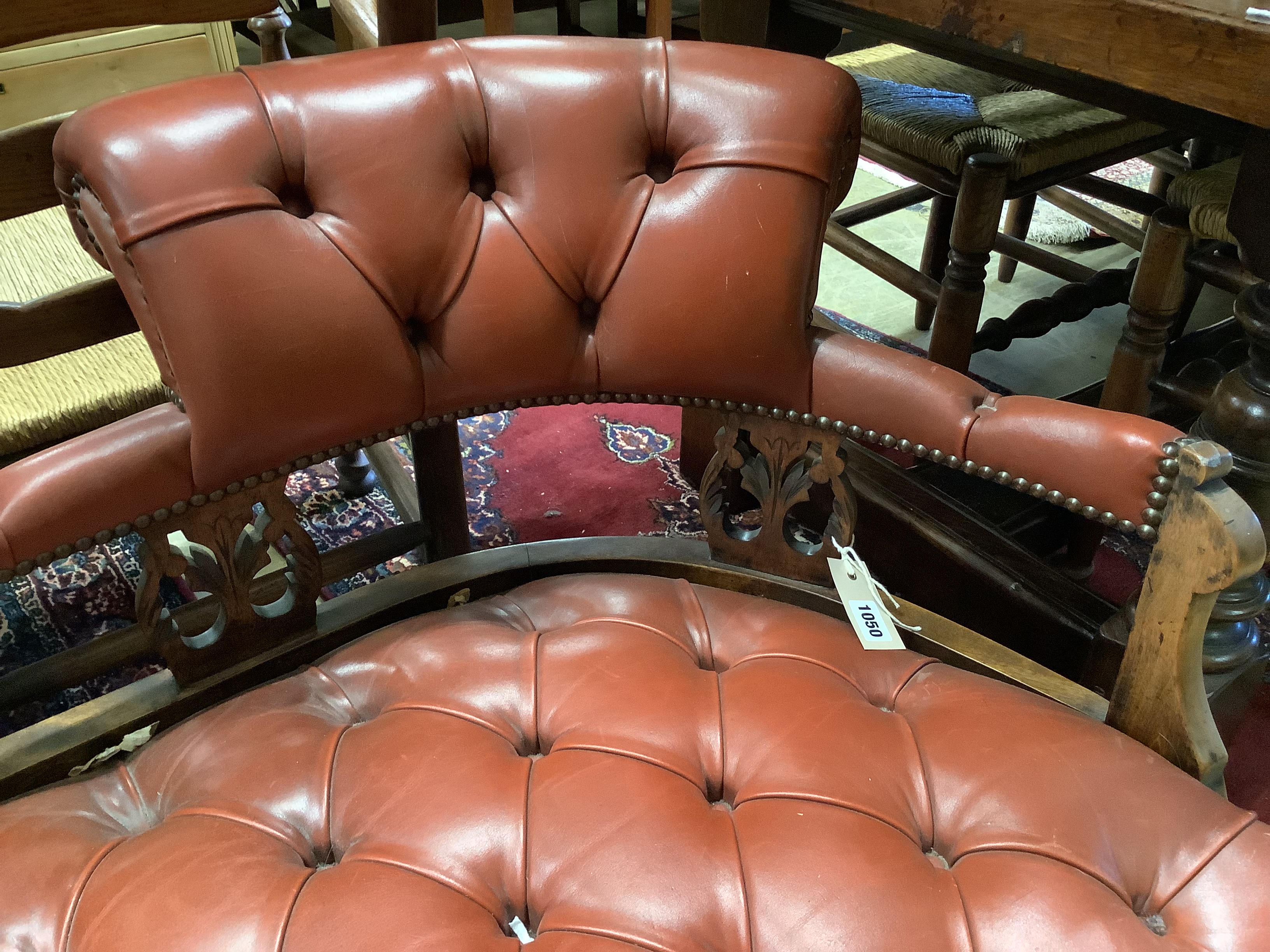 An Edwardian beech two-seater couch upholstered in buttoned burgundy hide on scrolled legs, length 160cm, depth 60cm, height 70cm